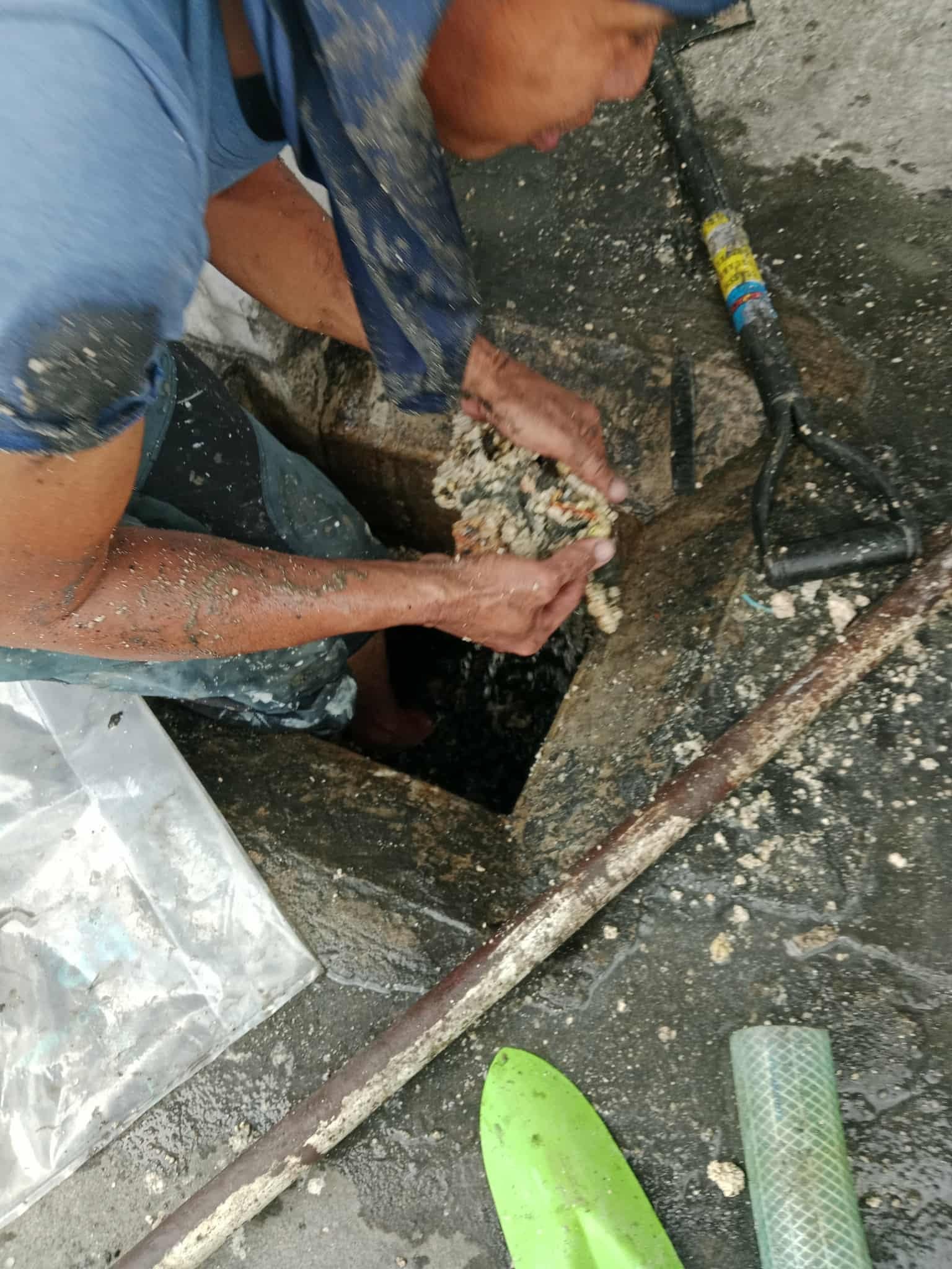Manual septic tank cleaning work involving removal of accumulated waste and debris