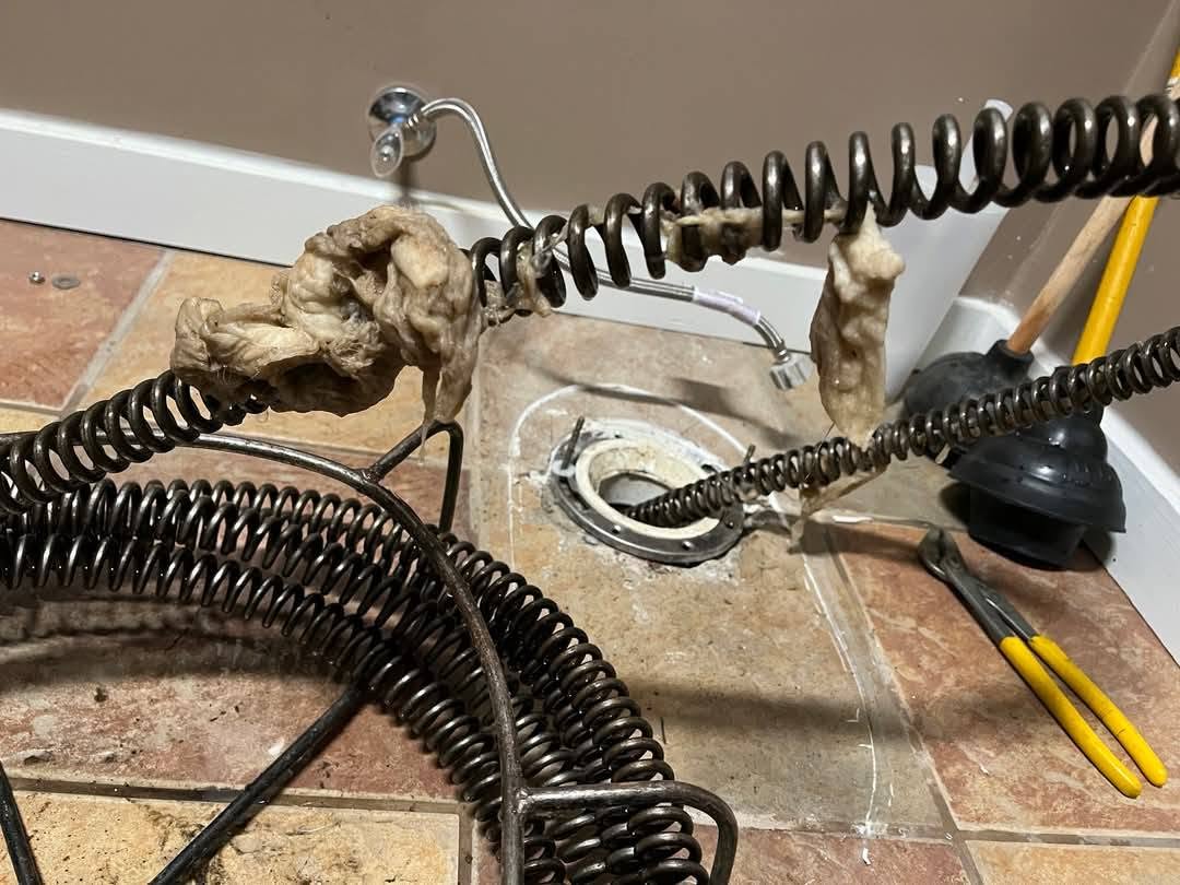 Toilet declogging using a drain auger to address a suspected obstruction